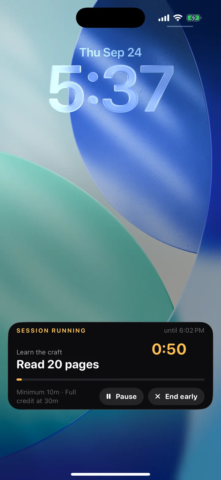 Actual iPhone lock screen: Locked In session Live Activity with the Read 20 pages task, countdown, pause and end early controls